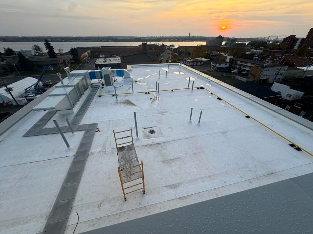 Walkway pads leading to rooftop units on the PVC roof OYH Roofing installed in Sault Ste. Marie, a flat roofing material detail for heavy Ontario winters