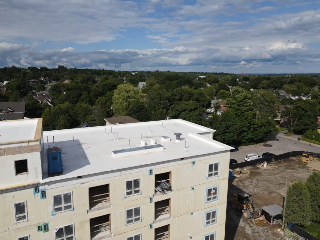 White PVC roof with vents and pipe penetrations that OYH Roofing installed on a new building in Sault Ste. Marie