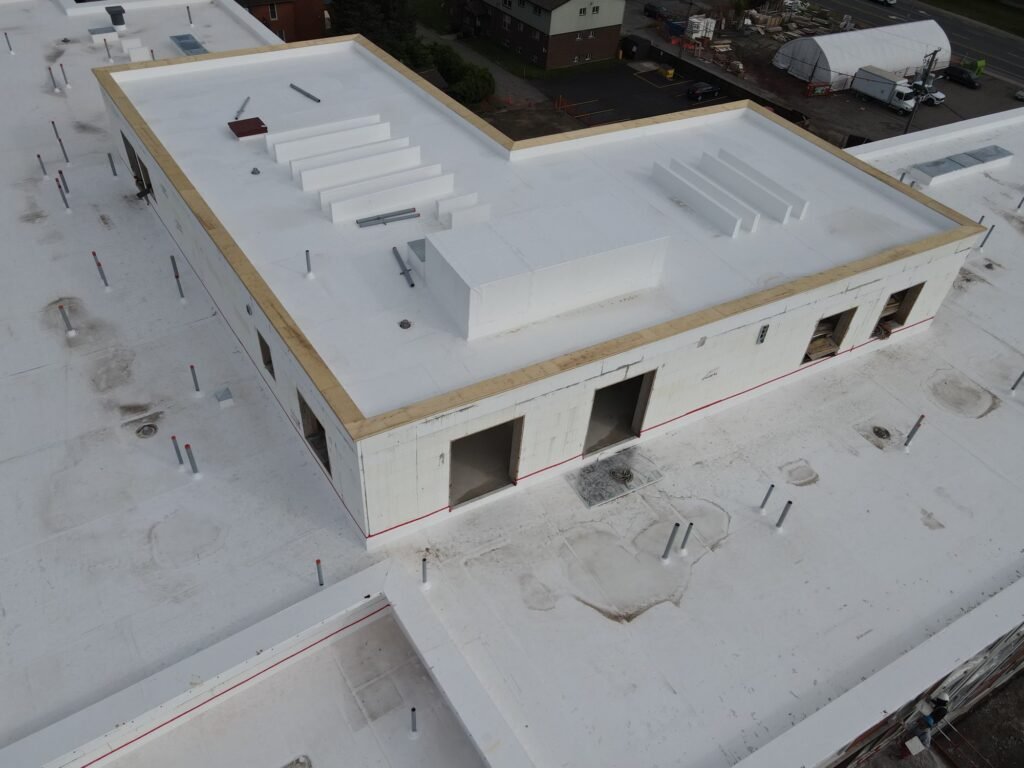 Rooftop mechanical room and parapets on a low-slope residential roof, the detail work an apartment building roof replacement involves